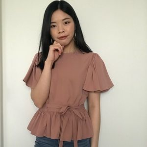 Super chic flutter sleeve, peplum top with optional tie. Can dress up or down!
